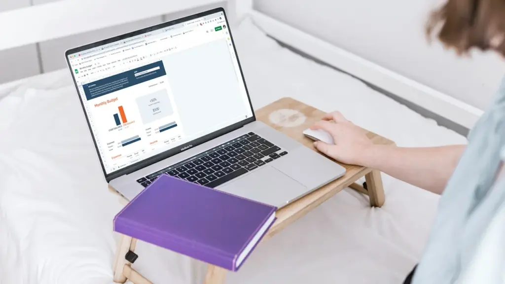 Person using laptop on bed