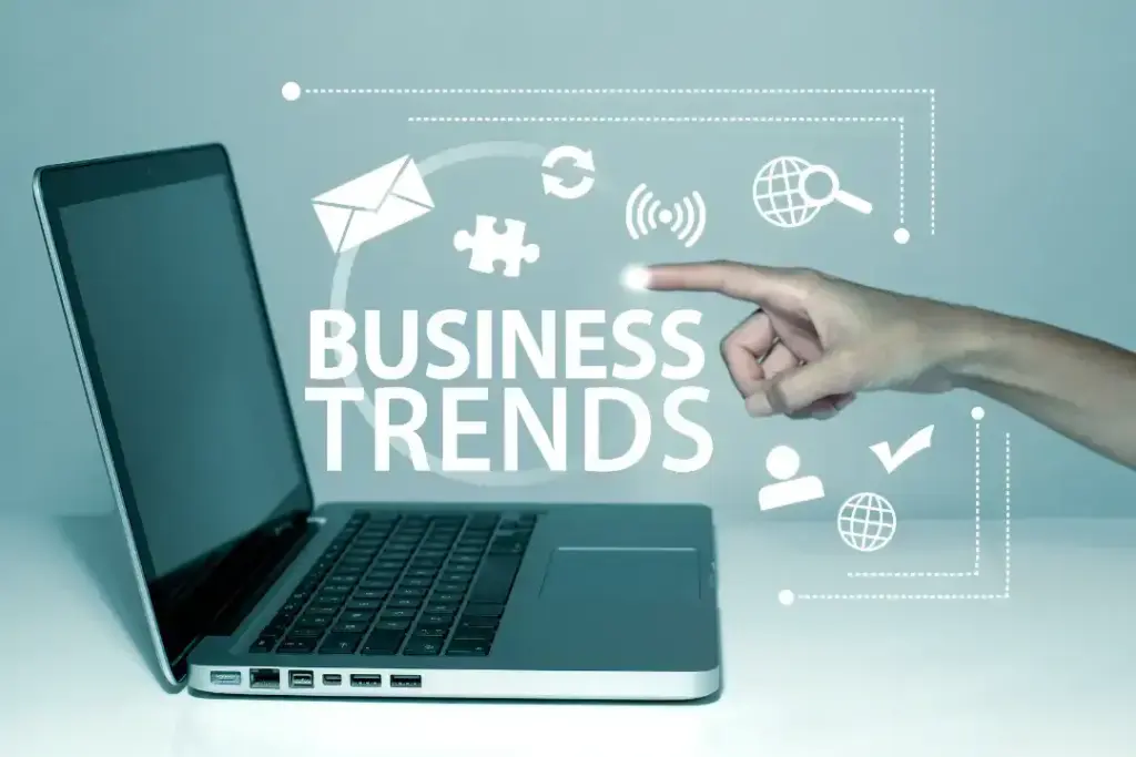 Finger pointing at business trends on laptop screen.