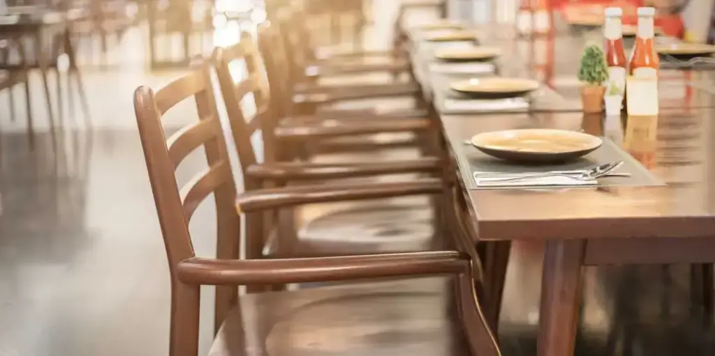 Empty restaurant table with chairs and settings
