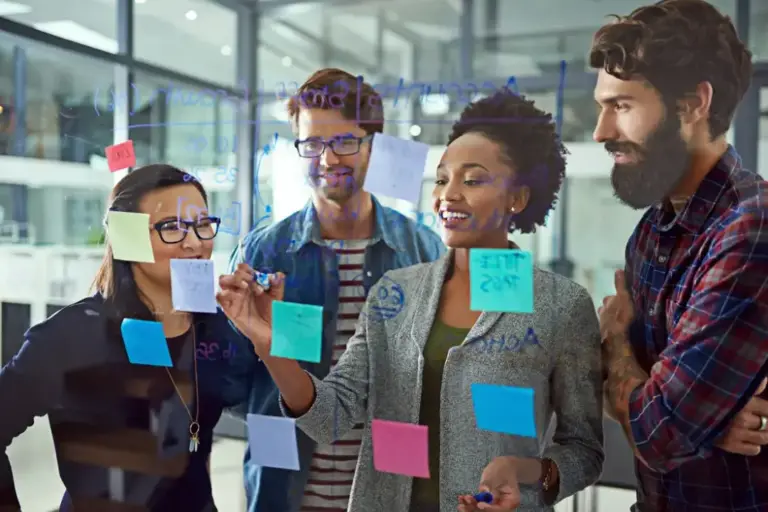 Team brainstorming with sticky notes on glass